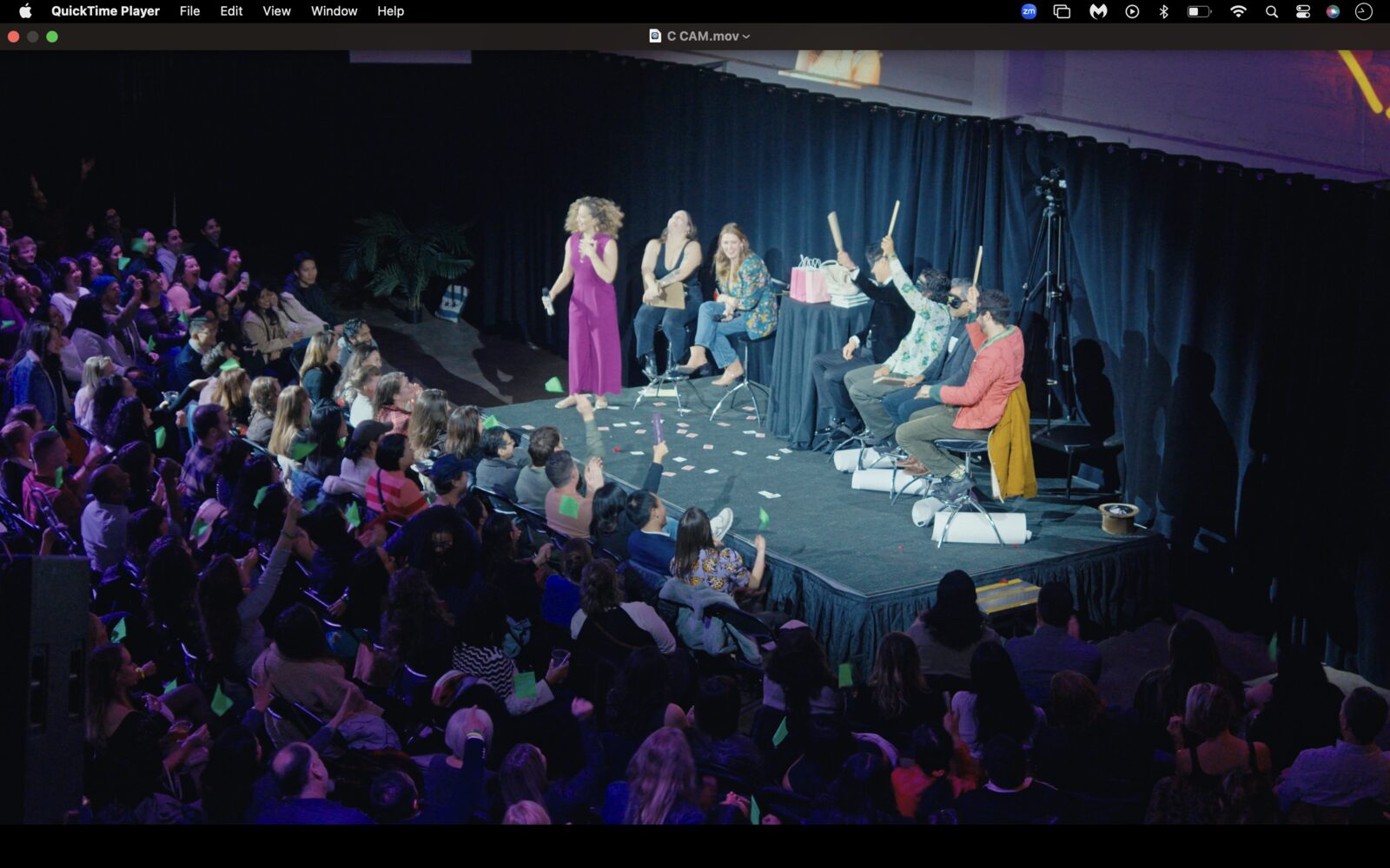 A huge crowd watching the stage under blue light